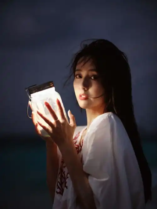 佟丽娅再晒海滩美照,化身执灯少女超温柔,笑容甜美如初恋