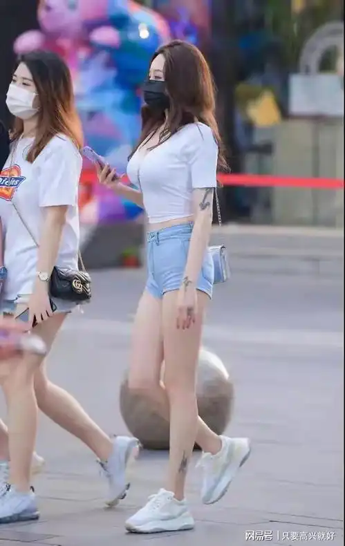 穿白色短袖搭配牛仔短裤秀长腿纹身的性感时尚女生