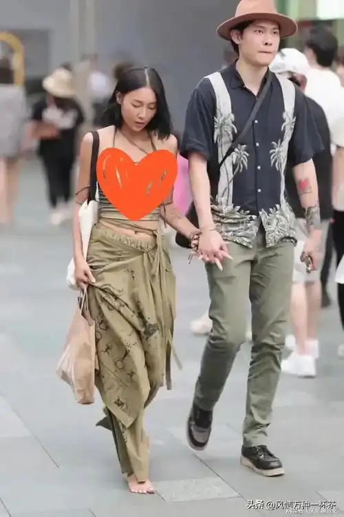 四川成都,一光脚的女子和一成熟稳重的男子手牵手走过热闹的街头