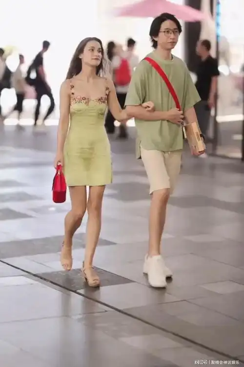 身材苗条的外国女子和成熟稳重的男子挽着手出现在热闹的街头